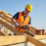 Construction worker cutting roof trusses on residential building site with MIP2J00 25.4cc compact gas chainsaw-minisawpro