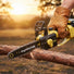 M11 mini lithium chainsaw sharp chain close-up cutting thick branch at farm field edge – compact cordless pruning saw-minisawpro