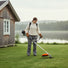 Woman maintaining Scandinavian lakeside summer house lawn with CLA200 35cc 4-stroke efficient gas grass trimmer-minisawpro