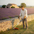 Man trimming grass around stone wall in Provence countryside with MIP139 4-stroke gas grass trimmer