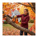 American woman pruning maple tree branches in New England autumn backyard with 2J000 25.4cc gas chainsaw-minisawpro