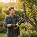 Man trimming tree branches in backyard garden with MiniSawPro M13 cordless mini chainsaw – lightweight pruning saw