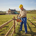 Construction worker trimming fence posts at rural farmhouse renovation with MIP2J00 25.4cc petrol chainsaw-minisawpro