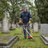 Professional landscaper trimming grass around historic cemetery gravestones with CLA220 52cc heavy-duty gas trimmer-minisawpro