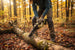 Woman cutting fallen log in autumn forest with MiniSawPro M10 mini chainsaw – portable cordless pruning saw outdoors